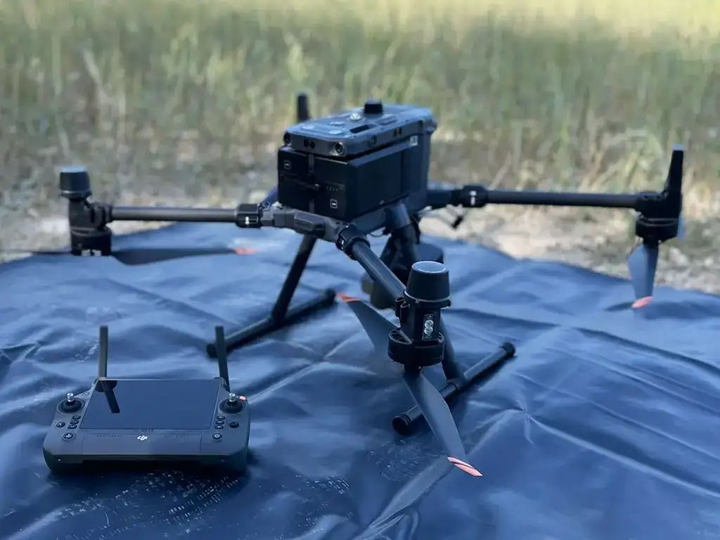 Dron con sensor LiDAR sobre una lona negra en el campo